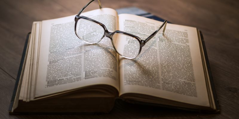 Livro e óculos sobre a mesa