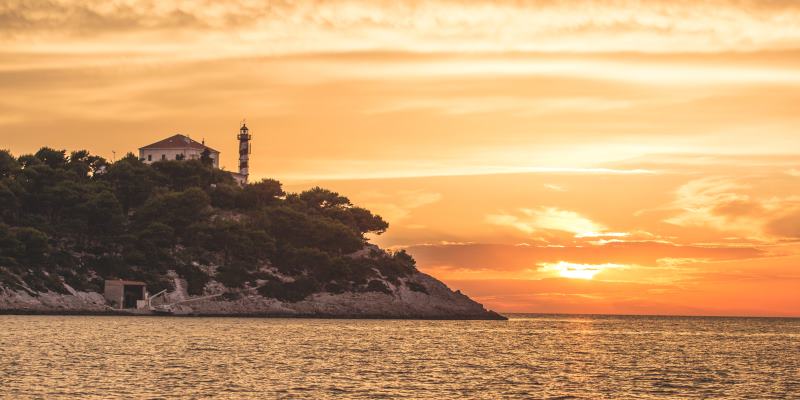 Farol na praia ao pôr do sol