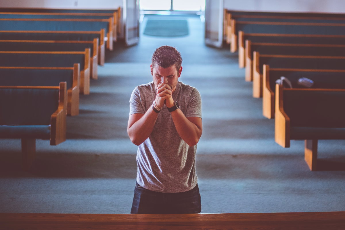 Homem orando em igreja representando as orações da bíblia
